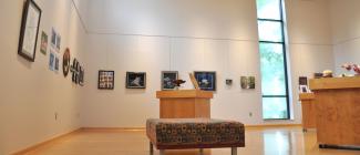 inside of the art gallery space with display of artwork hanging on the walls