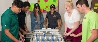 students playing foose ball game in student lounge